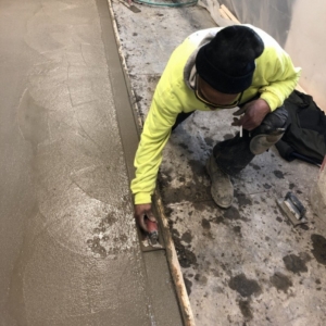photo of a man leveling cement