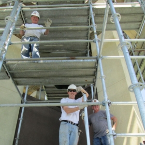 team of masons standing on scaffolding